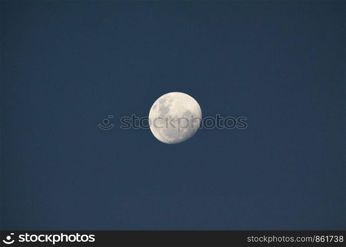 Great white moon close to blue sky