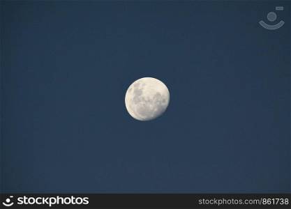 Great white moon close to blue sky