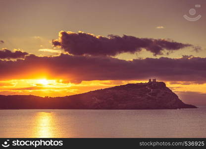 Greece Cape Sounion. Ruins of an ancient temple of Poseidon at morning sunrise, view from distance,. Greek temple of Poseidon at sunrise, Cape Sounio