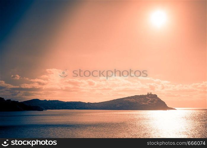 Greece Cape Sounion. Ruins of an ancient temple of Poseidon at morning sunrise, view from distance.. Greek temple of Poseidon at sunrise, Cape Sounio