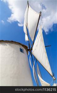 Greece. Cyclades. Paros island. White traditional windmill in the port of Parikia town against the blue sky