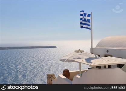 greece flag in wind at day with blue background