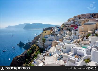 Greece. Summer sunny day in Santorini caldera. Balconies and white houses in Oia with sea views. Terraces with Balconies on Santorini Caldera on a Sunny Summer Day