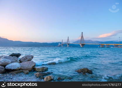 Greek cable-stayed bridge over the Gulf of Corinth. Rion-Antirion. Clear evening sky over the mountain shore. Greek bridge Rion Antirion at Evening