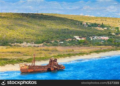 Greek coastline with the famous rusty shipwreck Dimitrios in Glyfada beach near Gytheio, Gythio Laconia Peloponnese Greece. View from distance.. The famous shipwreck near Gythio Greece