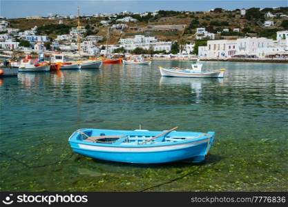 Greek fishing boat in clear sea water in port of Mykonos. Chora town, Mykonos, Greece. Greek fishing boat in port of Mykonos
