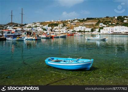 Greek fishing boat in clear sea water in port of Mykonos. Chora town, Mykonos, Greece. Greek fishing boat in port of Mykonos