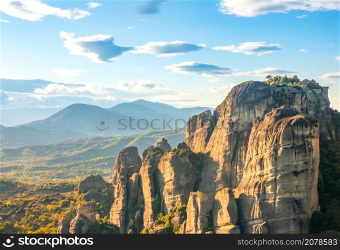 Greek Meteora. Sunny summer evening. Cliff monasteries. Evening Valley and Rocks of Meteora and Greek Monastery