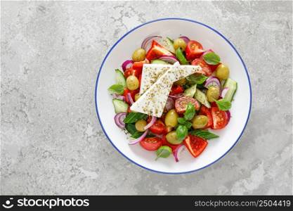 Greek or horiatiki salad with fresh vegetables and feta cheese, dressed with olive oil, traditional Greek cuisine salad. Top view