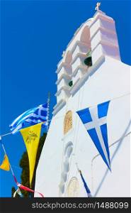Greek othodox church drcorated by flags in celebration, Mykonos island, Greece