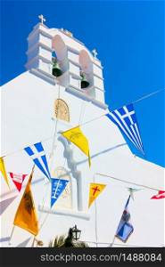 Greek othodox church drcorated by flags in celebration of religious holiday, Mykonos island, Greece