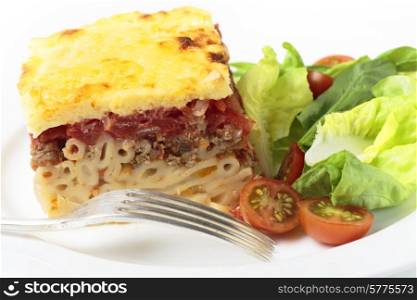 Greek pistatsio pasta topped with minced beef, tomatoes, bechamel sausce and cheese, served with a salad.