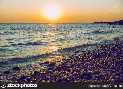 Greek Republic. Sunshine in sea and swimming people. In the distance mountains and sky. 17. Sep. 2019.