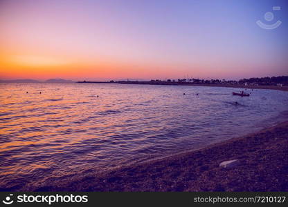 Greek Republic. Sunshine in sea and swimming people. In the distance mountains and sky. 17. Sep. 2019.