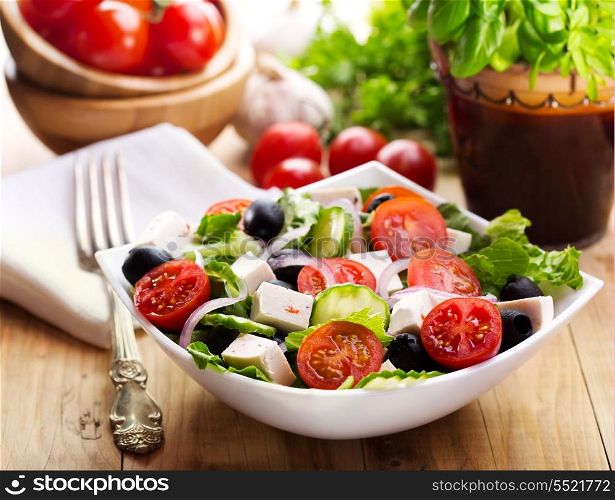 greek salad in a bowl on wooden table