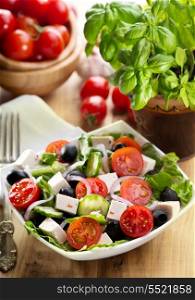greek salad in a bowl on wooden table