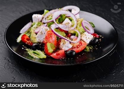 Greek salad in black bowl on stone