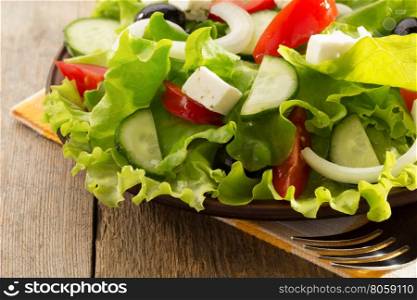 greek salad on wooden background