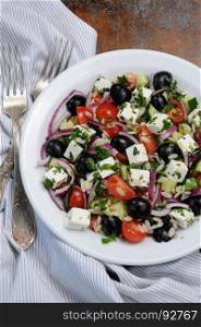 Greek salad orzo pasta with black olive, red onion and cucumber, cherry tomatoes, feta and herbs. Vertically shot. View from above