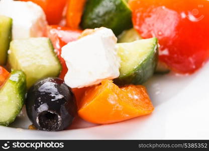 Greek salad with feta cheese macro on white plate