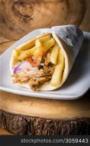 Greek style sandwich wrap served with pita and french fries and Tzatziki and chicken