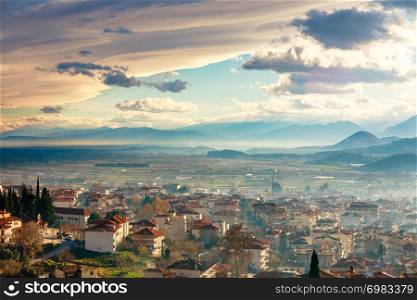 Greek town evening panorama with red roof houses, valley and mountains in the background, Kalambaka, Thessaly, Greece