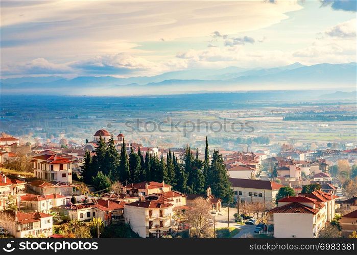 Greek town evening panorama with red roof houses, valley and mountains in the background, Kalambaka, Thessaly, Greece