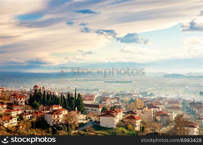 Greek town sunset panorama with red roof houses, valley and mountains in the background, Kalambaka, Thessaly, Greece