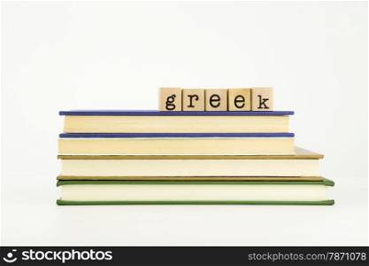 greek word on wood stamps stack on books, language and academic concept