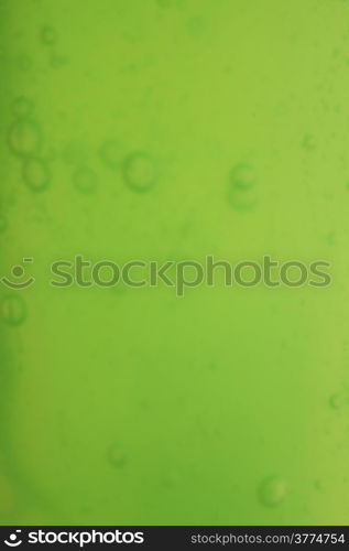 Green abstract blurred liquid background with soap bubbles