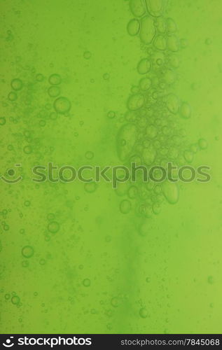 Green abstract blurred liquid background with soap bubbles