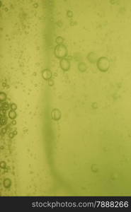 Green abstract blurred liquid background with soap bubbles