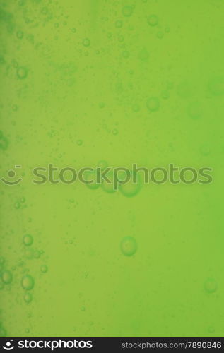 Green abstract blurred liquid background with soap bubbles