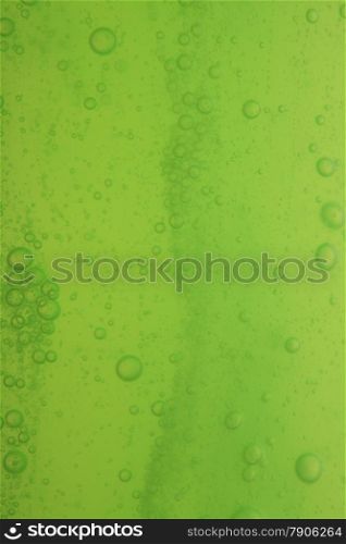 Green abstract blurred liquid background with soap bubbles