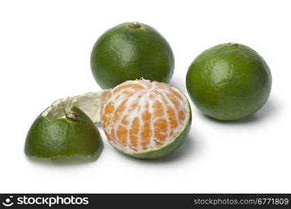 Green and peeled satsuma fruit on white background