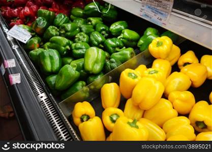 Green and red bell peppers display at a farmers market