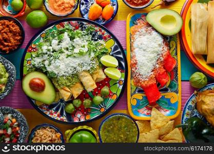 Green and red enchiladas with mexican sauces mix in colorful table