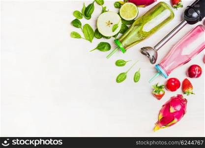 Green and red Smoothie bottles with fresh ingredients and electric blender on white wooden background, top view, border. Superfoods and health or detox diet food concept.
