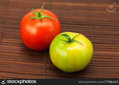 green and red tomatoes on a bamboo mat
