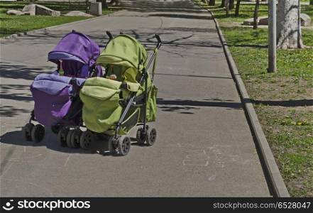 Green and violet baby pram outdoor in nature