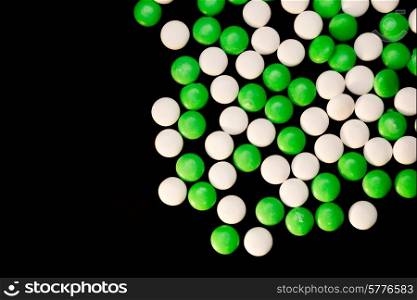Green and white mints scattered on a black background.