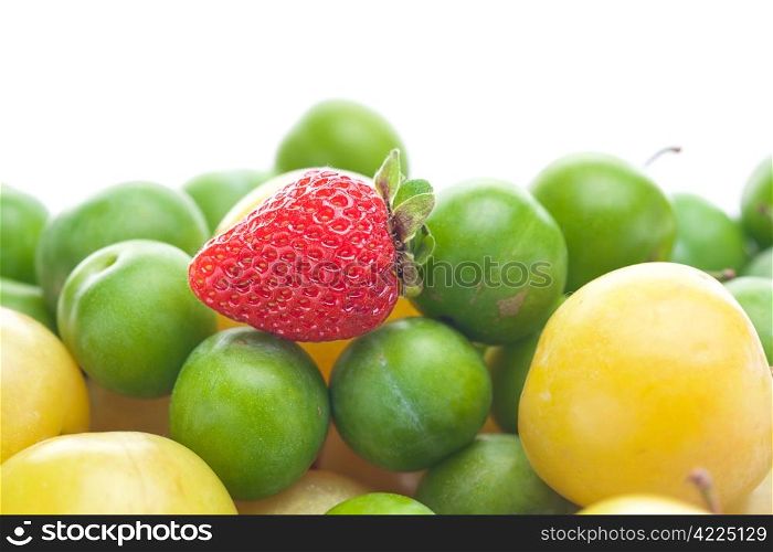 green and yellow plums and strawberries isolated on white