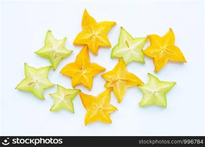 Green and yellow sliced ripe star fruit on white background