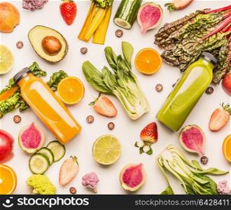 Green and yellow smoothie bottles with organic fruits and vegetables ingredients: kale, avocado,cucumber, orange, strawberries, blueberries on white desk background, top view, flat lay.