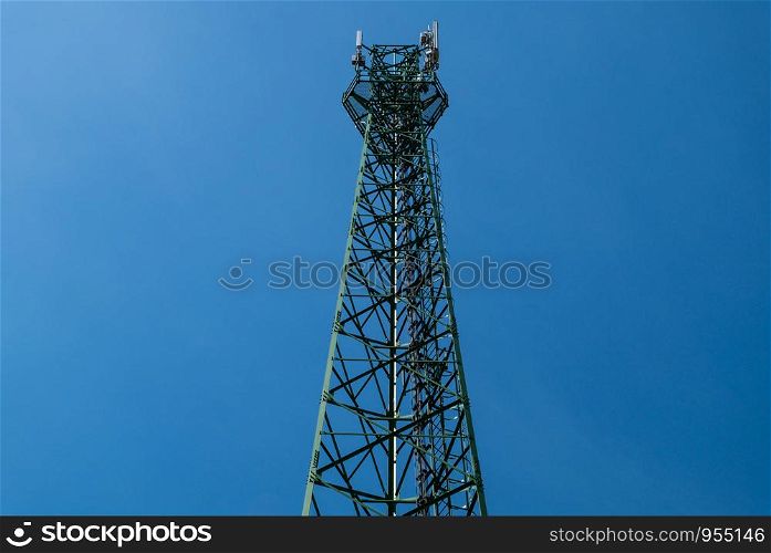 Green antenna tower with gradient blue sky background.
