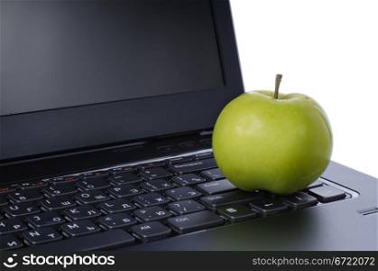 Green apple on laptop keyboard isolated on white background