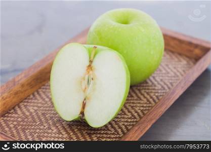 Green apple on wooden tray, stock photo