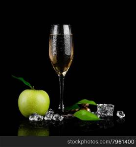 Green apple with a glass of champagne on black background