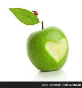 Green apple with cut heart and ladybird isolated on white