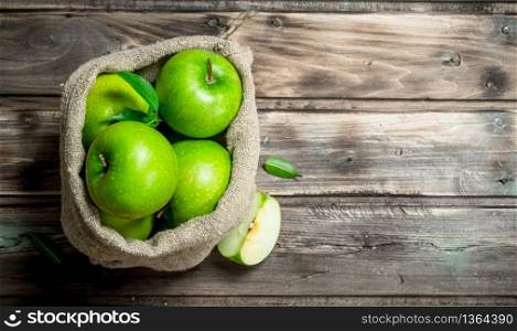 Green apples and Apple slices in an old bag. On grey wooden background.. Green apples and Apple slices in an old bag.